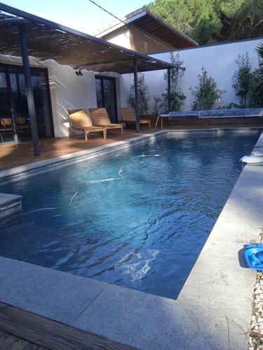 une piscine avec de l'eau bleue dans une maison dans l'établissement Corner of paradise with heated swimming pool, à Aigues-Mortes