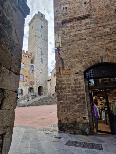 a person standing in a store in front of a castle at Appartamento Sotto le Torri in San Gimignano