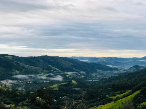 a view of a valley with fog in the hills at Casa do Vale in Serra Negra