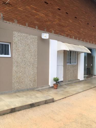 a brick building with a white awning and a plant at Casa do Vale in Serra Negra