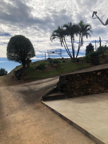 a dirt road with palm trees and a playground at Casa do Vale in Serra Negra