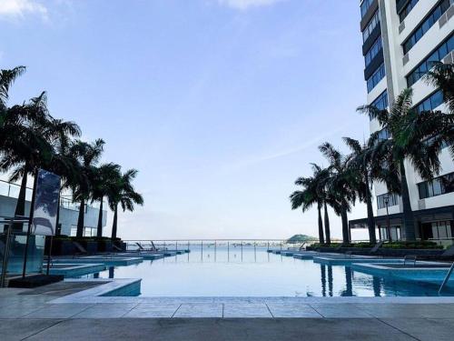 uma piscina com palmeiras em frente a um edifício em Linda vista al río. Seguridad y Parqueo em Guayaquil