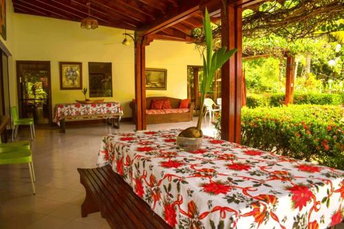 Zimmer mit einem Tisch und einer roten und weißen Decke in der Unterkunft Villas Mamilú. entrada y salida cien por ciento flexible in Santa Fe de Antioquia
