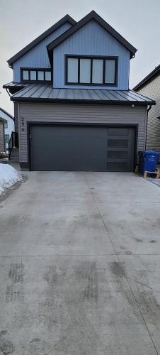 una casa con dos puertas de garaje en una entrada en Entire Basement Suite with Private Entrance, en Winnipeg