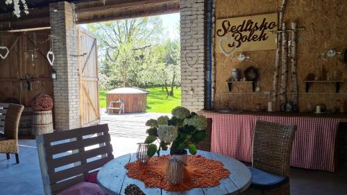 una mesa con un jarrón de flores sobre una mesa en Siedlisko Bolek, en Nadrybie