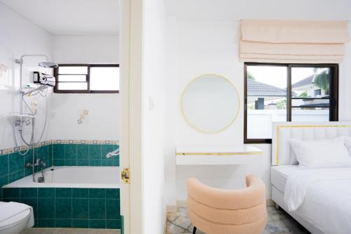 a bedroom with a bed and a bathtub and a chair at Di Pool Villa Hunhin 2km from beach in Hua Hin