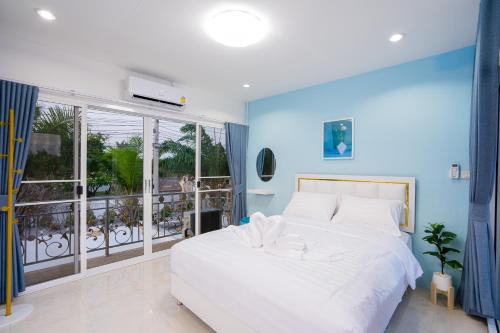 a bedroom with a white bed and a large window at Di Pool Villa Hunhin 2km from beach in Hua Hin