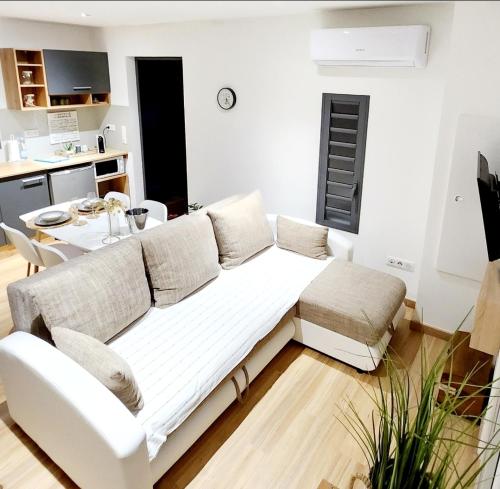 a living room with a white couch and a table at Au Doux Refuge in Le Lambert