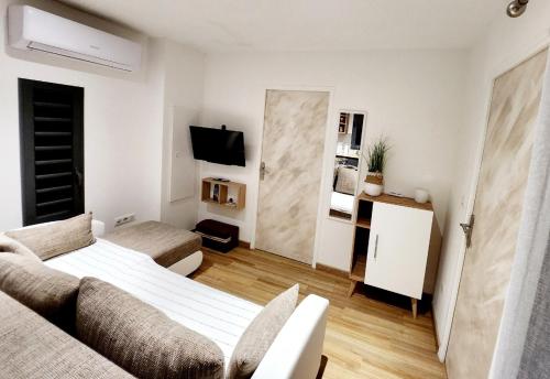 ein Wohnzimmer mit einem Bett und einem Sofa in der Unterkunft Au Doux Refuge in Le Lambert