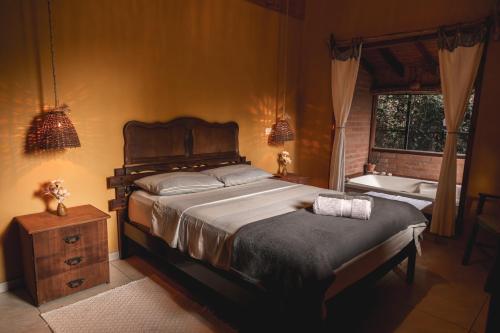 מיטה או מיטות בחדר ב-Casa Pedacinho de Céu com banheira de hidromassagem e lareira