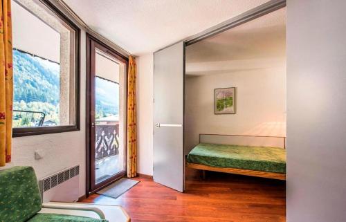 1 dormitorio con cama y ventana grande en L'Aiguille - maeva Home - 2 Pièces 5 Personnes Confort 76 en Chamonix-Mont-Blanc