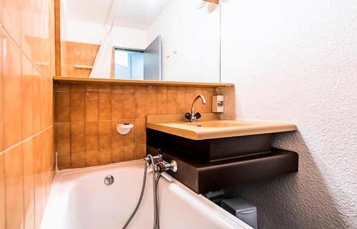 une salle de bain avec un lavabo et une baignoire dans l'établissement L'Aiguille - maeva Home - 2 Pièces 5 Personnes Confort MAE-1176, à Chamonix-Mont-Blanc