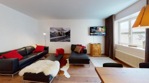 a living room with a couch and a table at Paravicini 5 in St. Moritz