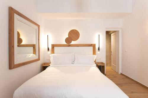 a bedroom with a large white bed and a mirror at Spitarona Town House - Largest VIlla in the Center in Mýkonos City