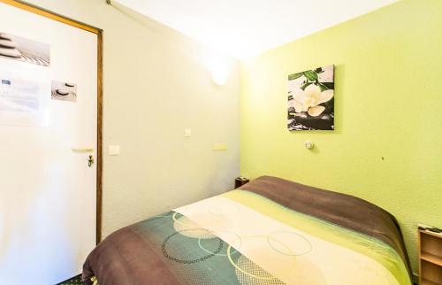 une petite chambre avec un lit et un miroir dans l'établissement Résidence Le Sextant - maeva Home - 2 Pièces 4 Personnes Confort MAE-1201, à La Plagne Tarentaise