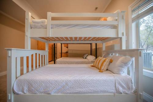 two white bunk beds in a room with a window at Scenic Hills in North Salt Lake