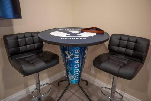 a table with two black chairs and a table with a football at Scenic Hills in North Salt Lake