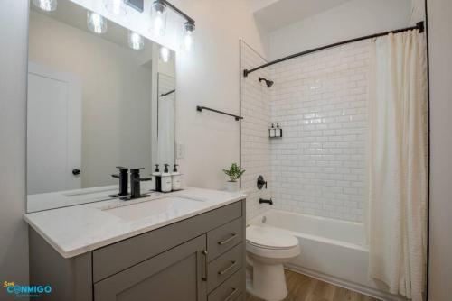 Un baño blanco con lavabo e inodoro. en Euclid, en Salt Lake City