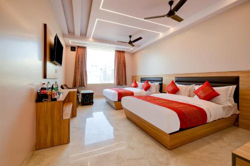 una camera d'albergo con due letti e una televisione di Hotel Express 66 - New Delhi Railway Station a Nuova Delhi