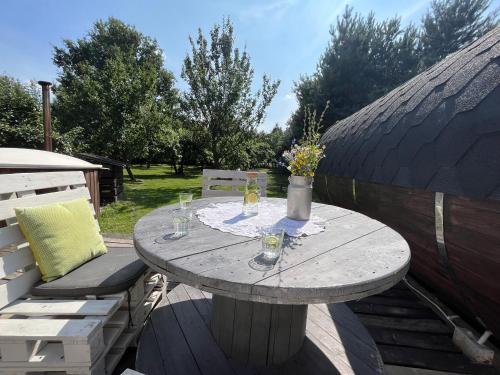 a table with drinks and flowers on a patio at Siedlisko Bolek in Nadrybie