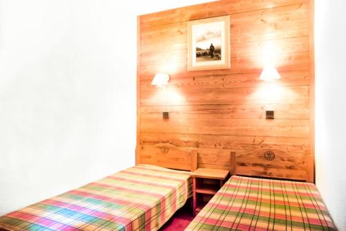 ein Schlafzimmer mit einem Bett und einer Bank darin in der Unterkunft Les Résidences de Valmorel - maeva Home - 2 Pièces 5 Personnes Confort 77 in Valmorel