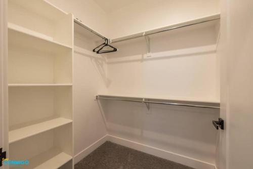 a walk in closet with white shelves and a light at Navien Nooks Unit 3 in Salt Lake City