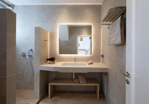 ein Bad mit einem Waschbecken und einem Spiegel in der Unterkunft Spitarona Town House - Largest VIlla in the Center in Mykonos Stadt