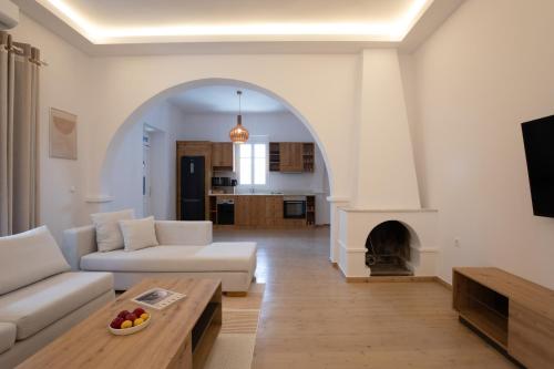 un soggiorno con divano e camino di Spitarona Town House - Largest VIlla in the Center a Mykonos Città