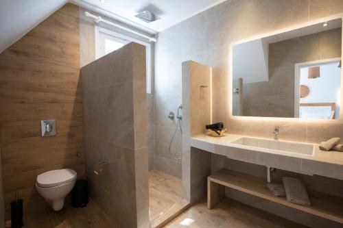 a bathroom with a sink and a toilet and a mirror at Spitarona Town House - Largest VIlla in the Center in Mýkonos City