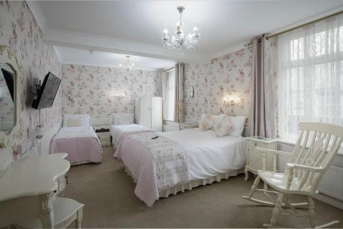 a bedroom with two beds and a chandelier at The Wescoe Guesthouse in Blackpool