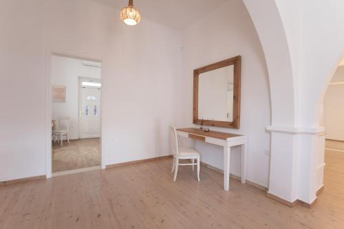 a white room with a desk and a mirror at Spitarona Town House - Largest VIlla in the Center in Mýkonos City