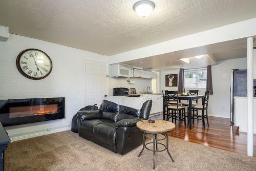 a living room with a couch and a clock on the wall at Grumpy Grizzly in Sandy
