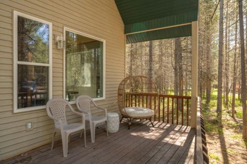 a porch with two chairs and a table and a stool at Bills Island Hideaway in Island Park
