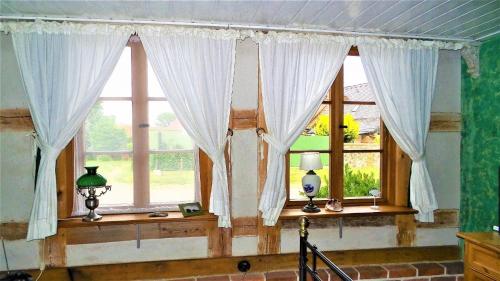 Zimmer mit 2 Fenstern und weißen Vorhängen in der Unterkunft Saniertes historisches Fischerhaus Godewind rechte Haushälfte mit Studio in Altwarp