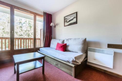 een woonkamer met een bank en een tafel bij Résidence L'Albane - maeva Home - 3 Pièces 7 Personnes Prestige 03 in Vars
