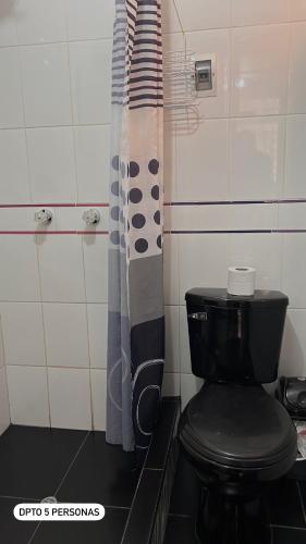 a bathroom with a toilet and a shower curtain at El Viejo Roble in Cusco