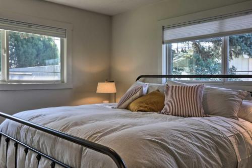 a dog laying on a bed with two windows at Riverview Retreat in Idaho Falls