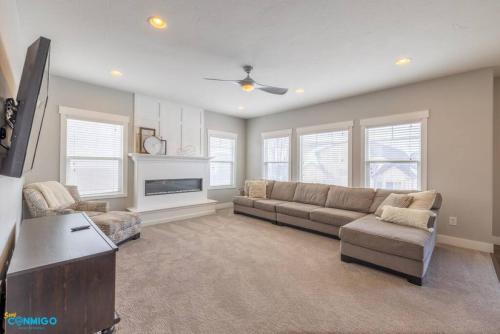 a living room with a couch and a tv at Oquirrh Mountain Haven in South Jordan