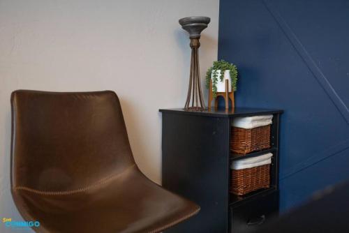 a brown chair sitting next to a shelf with a plant at Oquirrh Mountain Haven in South Jordan