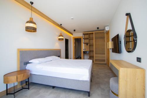 een slaapkamer met een bed, een tafel en een stoel bij Asterina Hotel in Turgutreis