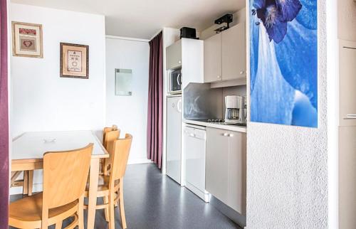 une cuisine et une salle à manger avec une table et des chaises dans l'établissement Résidence Antarès - maeva Home - 2 Pièces 7 Personnes Sélection MAE-1422, à Avoriaz