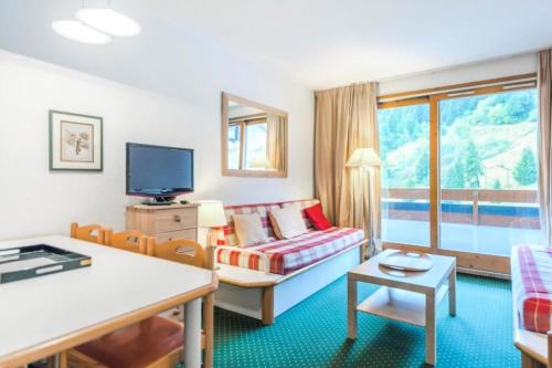 Cette chambre d'hôtel dispose d'un canapé et d'une télévision. dans l'établissement Résidence Les Sentiers du Tueda - maeva Home - 2 Pièces 6 Personnes Sélection MAE-1311, à Les Allues