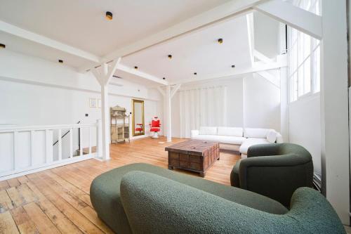 a living room with a couch and a table at Sublime Loft à St Germain (3 chambres) in Paris