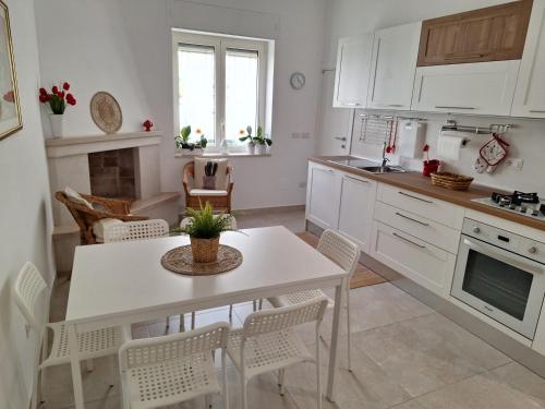 a kitchen with a white table and chairs in a room at Casa Vacanze Al Parco in Casamassima