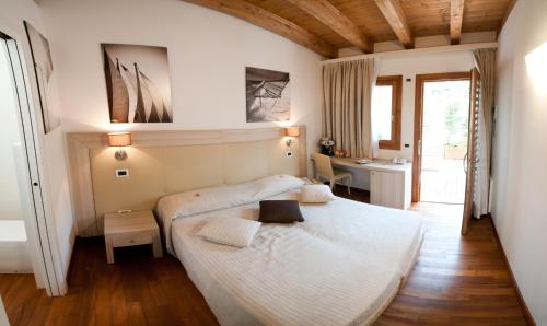 A bed or beds in a room at Tre Merli Beach Hotel