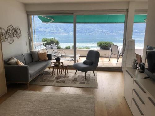 uma sala de estar com um sofá e vista para o oceano em Ascona Residenz Sollevante em Ascona