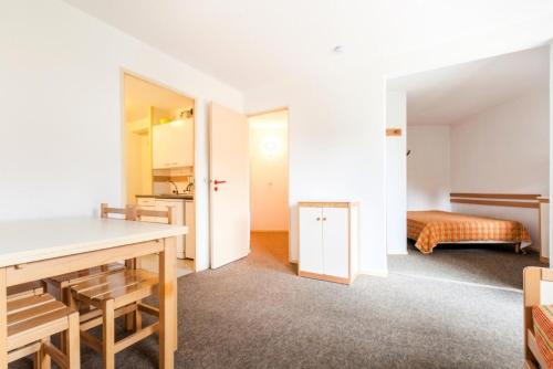 Cette chambre comprend une table et un lit. dans l'établissement Résidence L'Eyssina - maeva Home - Appartement 2 Pièces 6 Personnes - Budget MAE-1420, à Vars