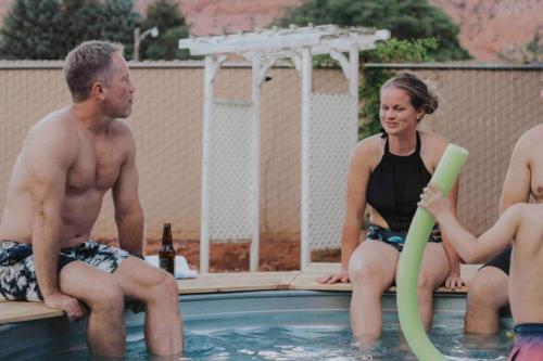 a man and a woman sitting in a swimming pool at Lake House Escape, Venture Base Unit 7 in Kanab