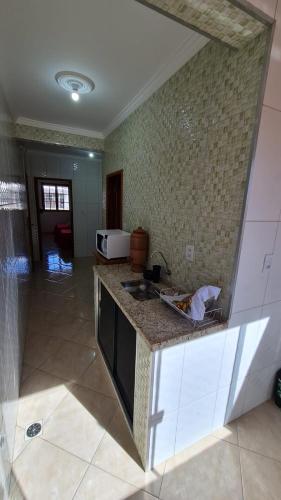a kitchen with a sink and a counter top at Hotel e Pousada Ed1000son in São João del Rei