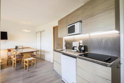 une cuisine avec un évier et un plan de travail dans l'établissement Résidence Le Hameau du Sauget - maeva Home - 3 Pièces 6 Personnes Sélection MAE-1979, à La Plagne Tarentaise